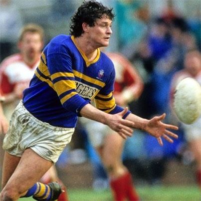 Peter Jackson playing rugby while wearing a blue and yellow top and white shorts