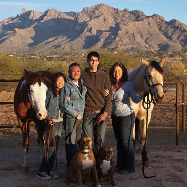 Peter M. Rhee posing with his entire family along with some horses in a ranch.