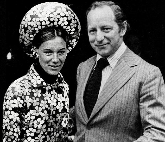 Bill Shand-Kydd smiling and wearing striped coat, long sleeves and neck tie while his wife wearing floral dress