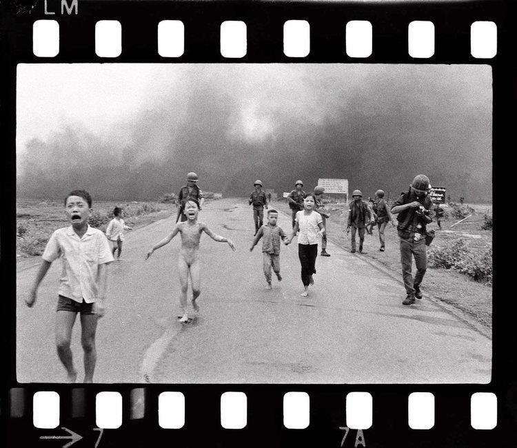 Young Phan Thi Kim Phuc (center left) running down a road naked while crying near Trảng Bàng after a South Vietnam Air Force napalm attack along with other children and soldiers in an old photograph