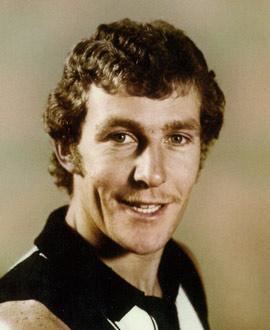 Phil Carman smiling with a curly hair and wearing a black and white shirt