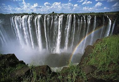 A curtain of waters with a rainbow in the spray of Victoria Falls