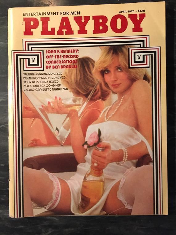 Valerie Perrine featured in the Playboy Magazine while holding a bottle of wine and wearing a white lingerie and pearl necklace