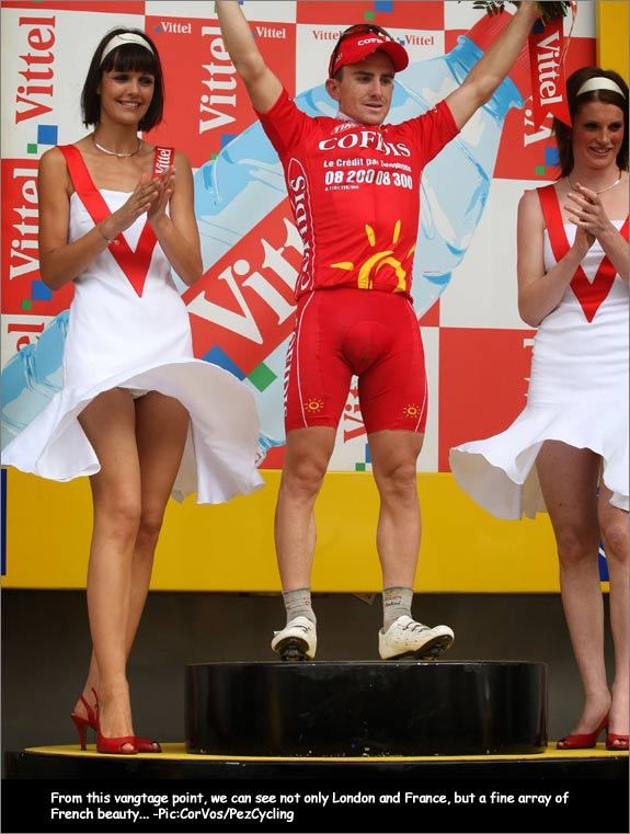 An unknown cyclist standing with two sexy podium girls beside him