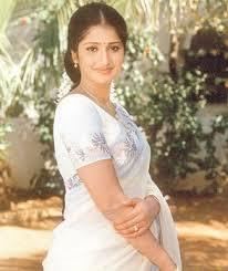 Prathyusha wearing earrings, a necklace, a ring, and a white dress.