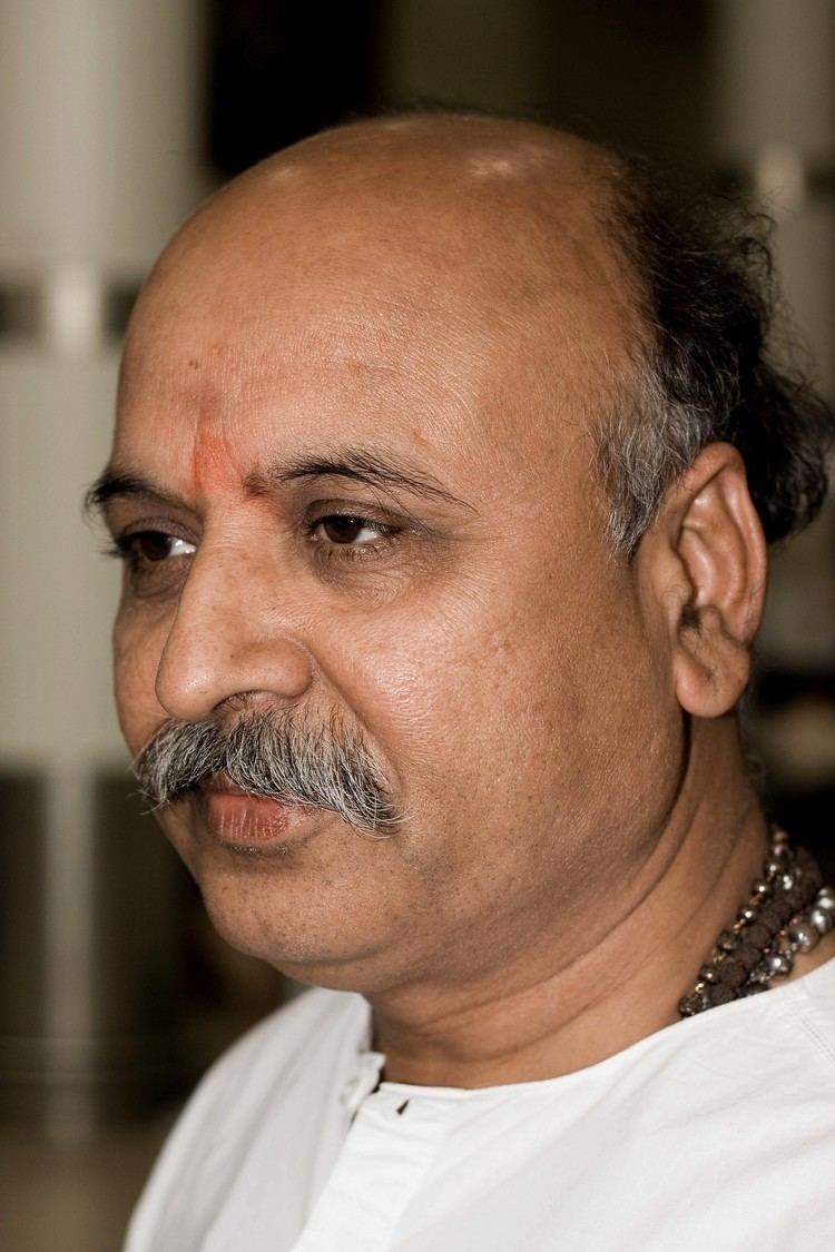 Pravin Togadia with mustache and wearing a white shirt and necklace