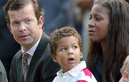 Prince Maximilian, Prince Alfons, Princess Angela of Liechtenstein (left to right) are looking at something with serious faces. Prince Maximilian is wearing a white long sleeve under a beige and blue necktie and black coat. Prince Alfons is wearing a white and pink polo shirt. Princess Angela is wearing a dark blue blouse