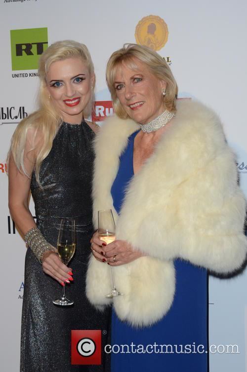 Princess Olga Andreevna Romanoff holding a glass of wine while wearing a formal attire with a woman beside her