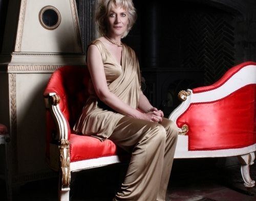 Princess Olga Andreevna Romanoff sitting on a chair while wearing a jumpsuit