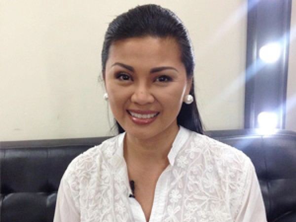 Princess Punzalan while sitting on a couch wearing a white long-sleeved shirt