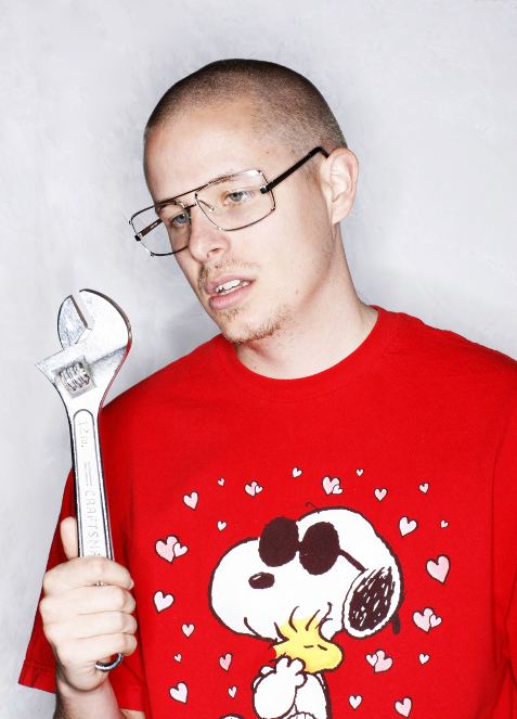 Prof holding a wrench and wearing eyeglasses and a red snoopy t-shirt