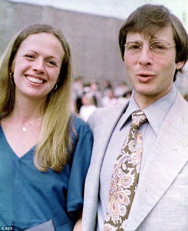Kathie Durst smiling while wearing a blue blouse and Robert Durst wearing eyeglasses, gray coat, light blue long sleeves and necktie