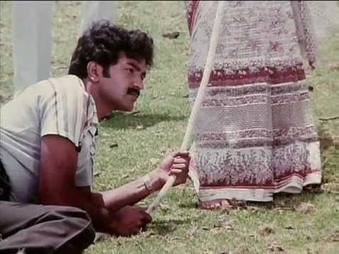Pandiyan lying on the ground in a movie scene from Pudhumai Penn (1984 film).