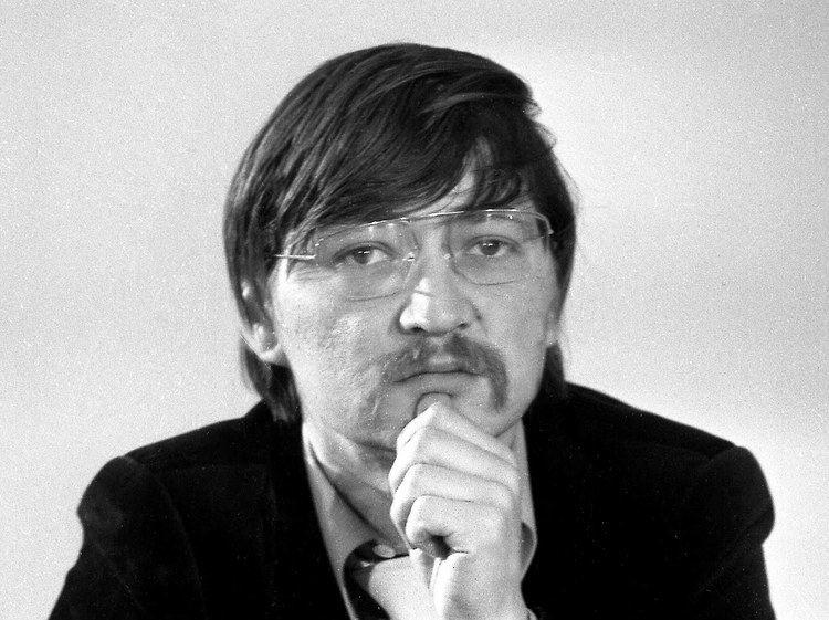 Rainer Werner wearing a black suit and a pair of eyeglasses