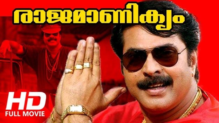 Movie poster of Rajamanikyam, a 2005 Indian Malayalam-language action Masala film featuring Mammootty smiling, with folded hands, a mustache, wearing sunglasses, gold necklace, gold rings, gold watch, and a red shirt.