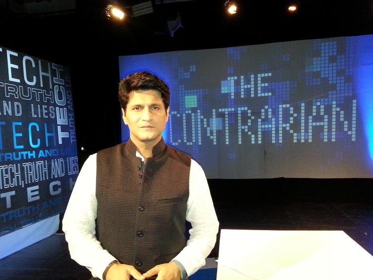 Rajiv Makhni sitting on the chair while wearing white long sleeves and a black vest