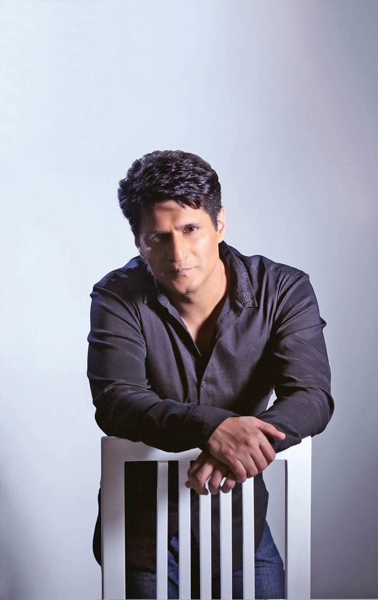 Rajiv Makhni with a tight-lipped smile while wearing a black long sleeves