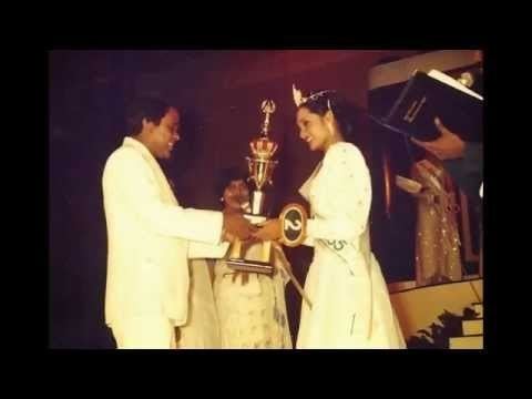 Ramani Bartholomeusz receiving her trophy while wearing white gown and crown