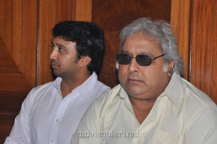 Ramkumar Ganesan wearing sunglasses, and a white polo shirt with a man on his side wearing white long sleeves.