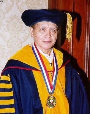 Ramon Barba wearing a blue and yellow academic dress and a medal