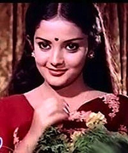 Ranipadmini's tight lipped smile while wearing red floral dress