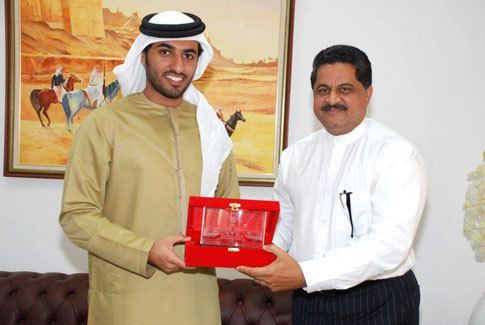 Rashid bin Humaid Al Nuaimi as he receives a special memento from the President of GMU