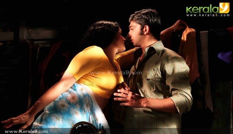 Shweta Menon and Sreejith Vijay staring at each other in a movie scene from the 2011 erotic drama film Rathinirvedam