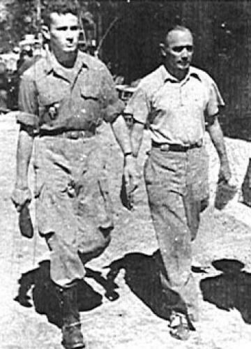 Raymond Maufrais walking with a man beside him