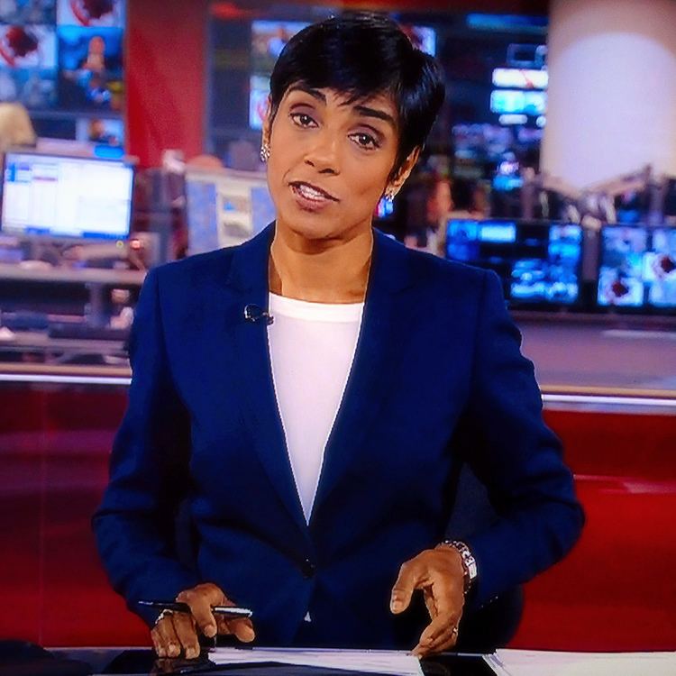Reeta Chakrabarti presenting a news report while wearing a blue blazer and white inner blouse