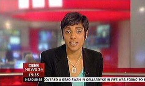 Reeta Chakrabarti presenting a news report while wearing a necklace, black blazer, and light blue blouse