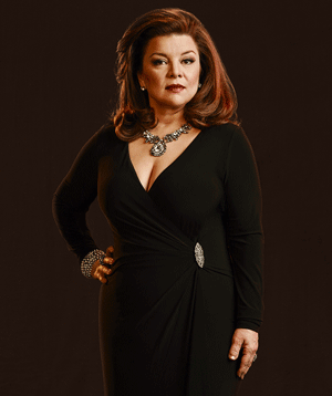 Renee Lawless' hand on her hips while wearing black long sleeve dress