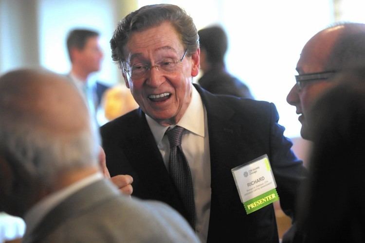 Richard Driehaus with a happy face and wearing eyeglasses while surrounded by people.