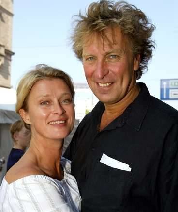 Richard Hobert smiling and wearing a black polo shirt while Lena Endre wearing a white blouse
