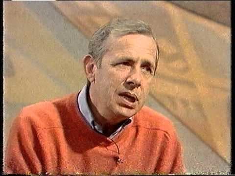 Richard O'Sullivan wearing an orange sweatshirt during an interview.