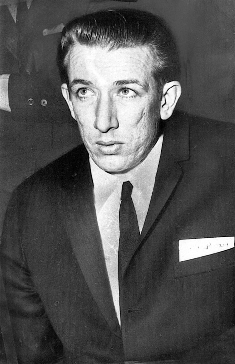 Richard Speck wearing a black coat, long sleeves, and necktie
