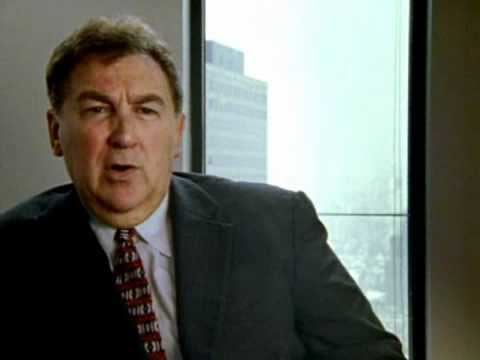 Rick Rescorla, in one of his interviews, wearing a black coat, white long sleeves, and necktie