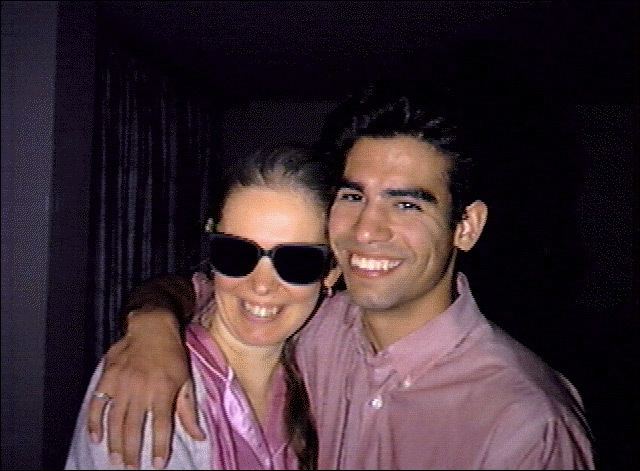 Ricky Rodriguez smiling and wearing pink long sleeves while the woman beside him wearing black shades and a pink blouse