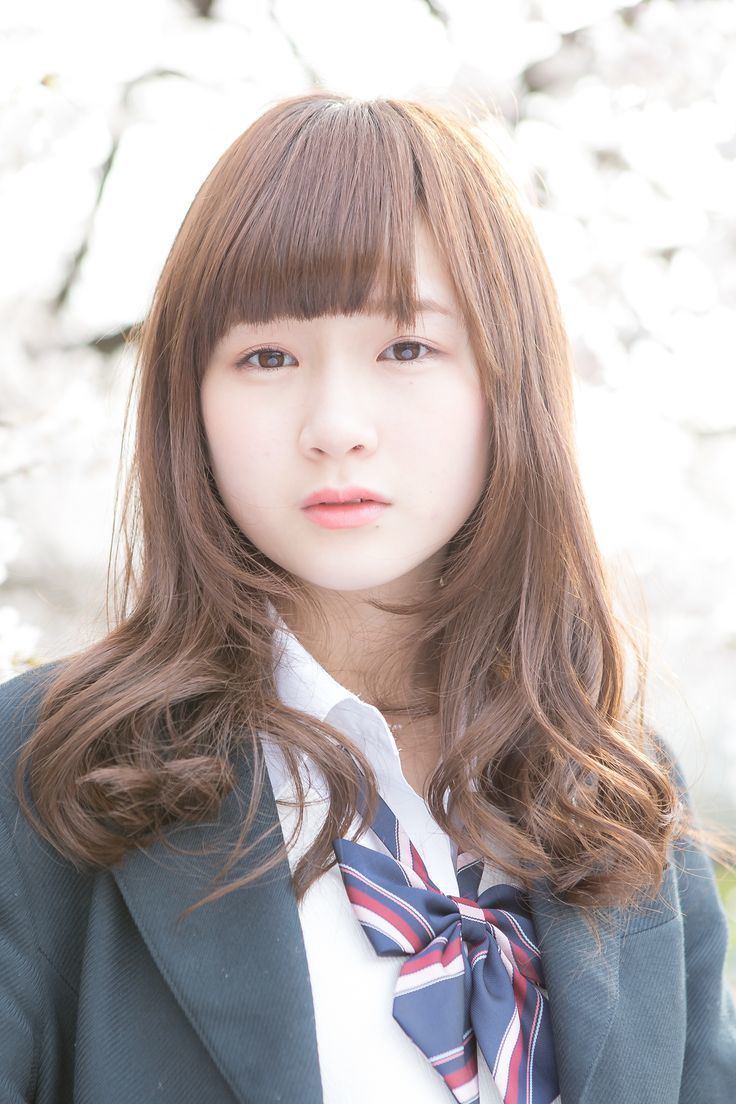 Rie Kaneko looking fierce and wearing a white blouse with a colored ribbon under a gray coat