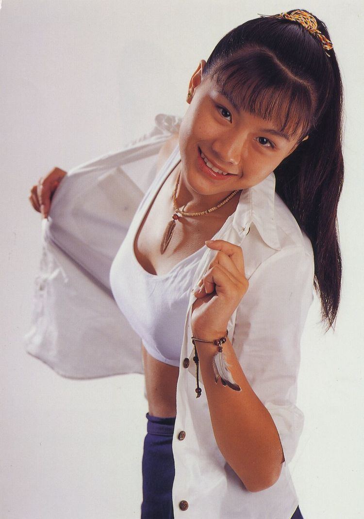 Rika Nishimura wearing white tops, blue jeans, a necklace, and a bracelet with ponytail hair.