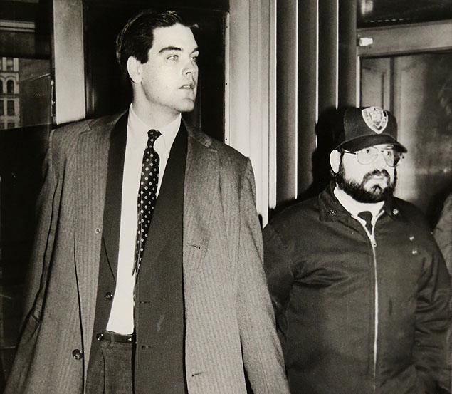 Robert Chambers Jr. and Court Officer Herb Koenig arrive with serious faces at Manhattan Criminal Court on the fourth day of deliberations in his murder trial in 1988. Robert is wearing a long sleeve under a polka dot necktie, vest, and striped coat while Herb with a mustache and beard is wearing cap, eyeglasses and a long sleeve under a necktie and jacket