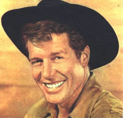 Robert Horton smiling, wearing a brown shirt and a black hat