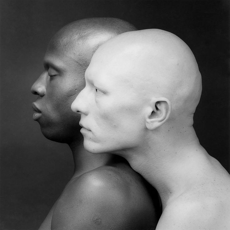 Ken Moody and Robert Sherman, 1984, with a side view pose with serious faces, bald heads, and topless, captured by Robert Mapplethorpe