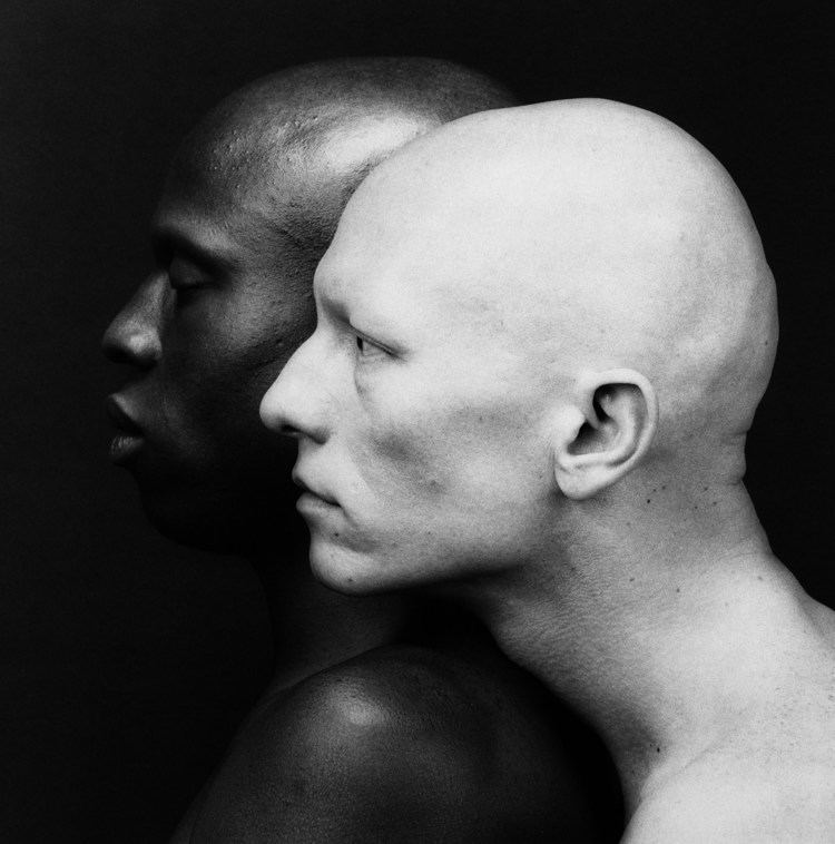 Ken Moody and Robert Sherman, 1984, with a side view pose with serious faces, bald heads, and topless, captured by Robert Mapplethorpe