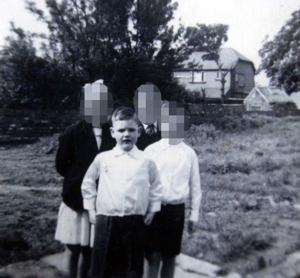 Robert John Maudsley with his siblings with a house at their back.