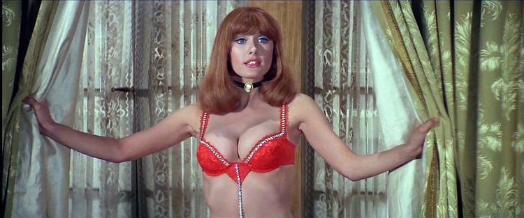 Robyn Hilton holding the curtain wearing a red two-piece bikini in a movie scene from Blazing Saddles (1974)