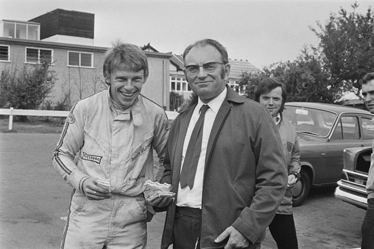 Roger Williamson smiling with English businessman and car collector Tom Wheatcroft while wearing a racing jacket.