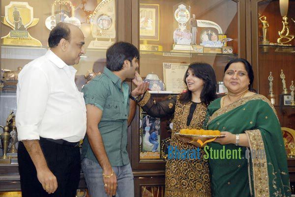 Roja Ramani smiling and wearing green and gold dress along with three people