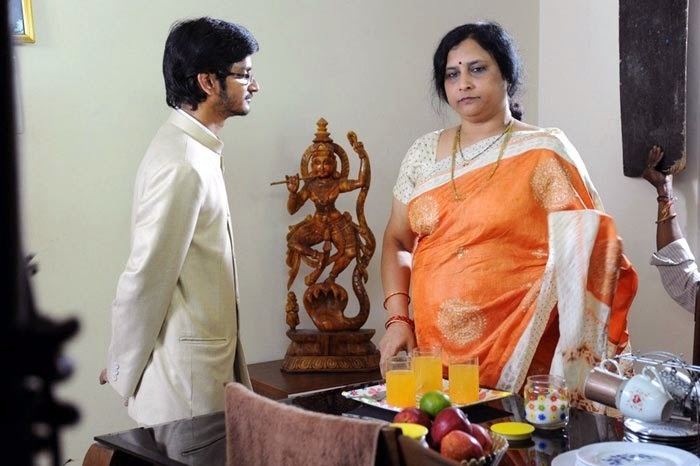 Roja Ramani wearing white and orange dress and the man beside him wearing white long sleeves