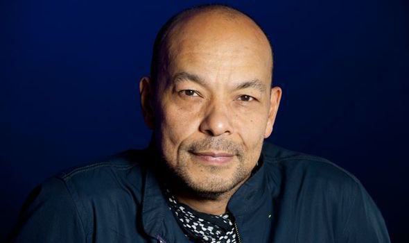 Roland Gift smiling and wearing a blue jacket