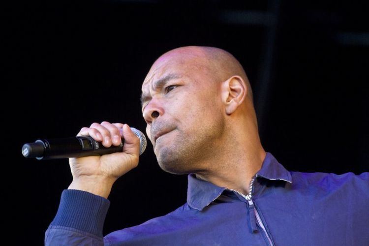 Roland Gift is singing and wearing a blue jacket